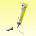 Skincare product tube with applicator on a yellow background