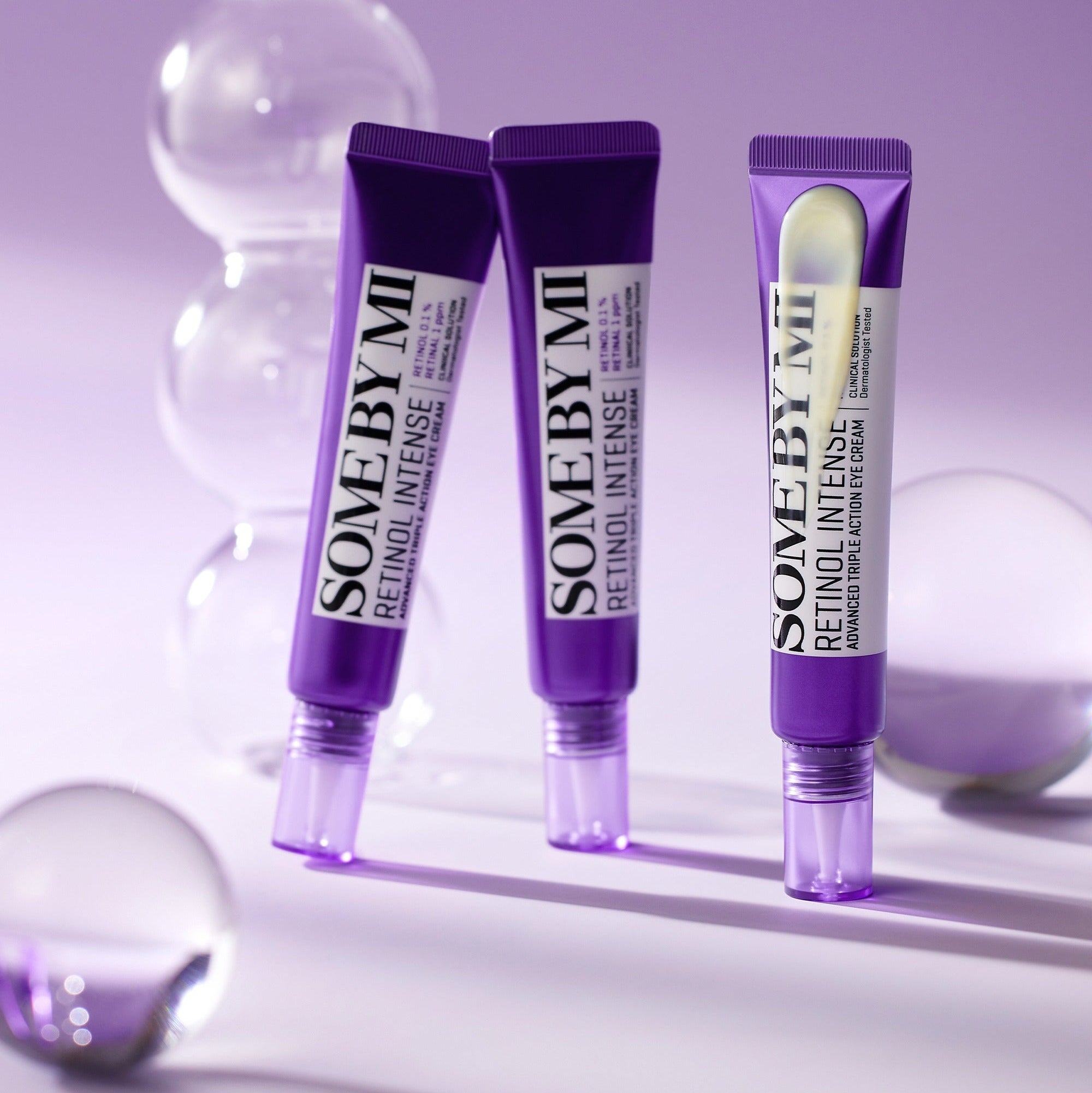 Three 'Some By Mi' Reinstil Intense skincare tubes on a purple background