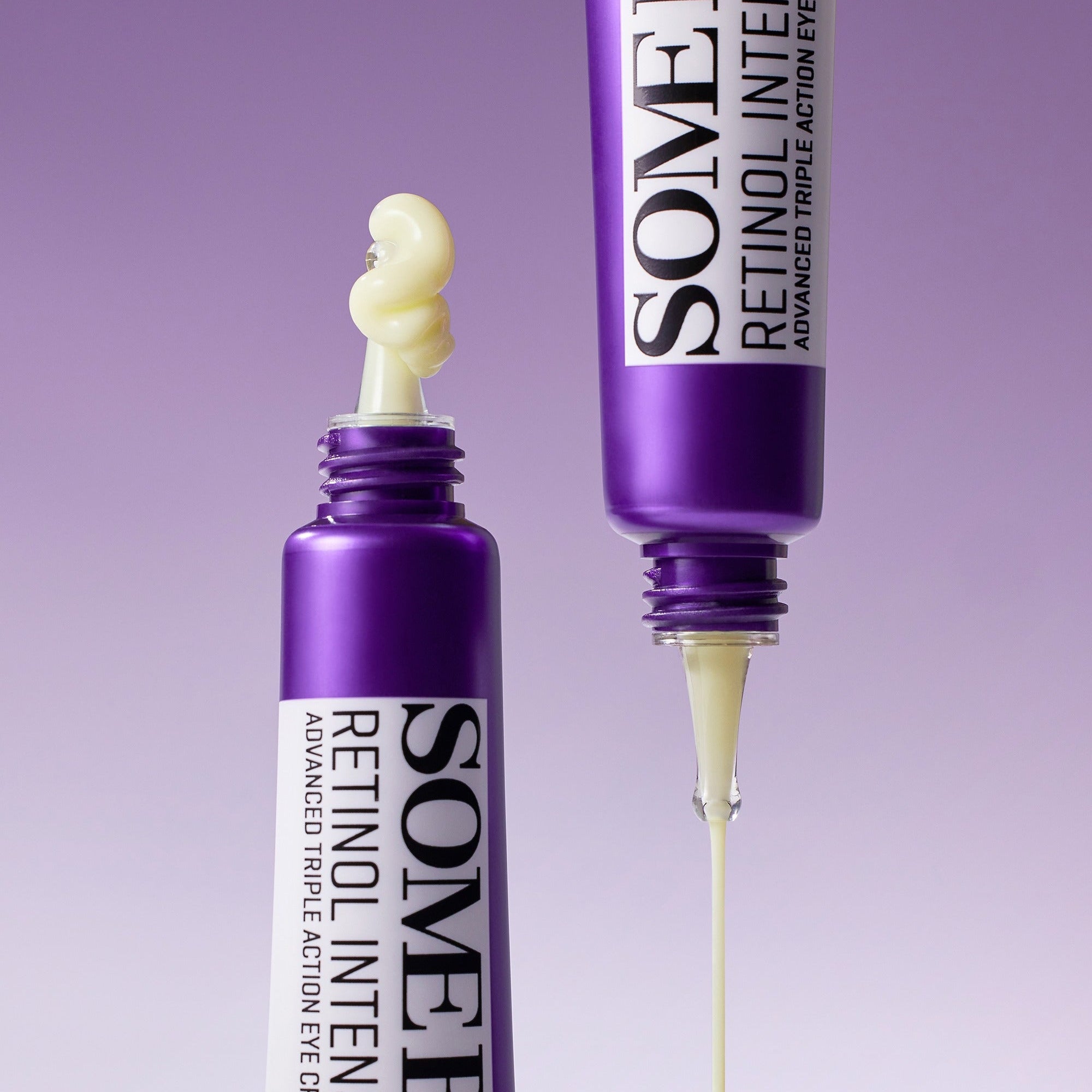 Two purple eye cream tubes with visible cream being dispensed on a purple background