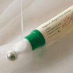 Vegan Collagen Eye serum with green cap and white body on a light background