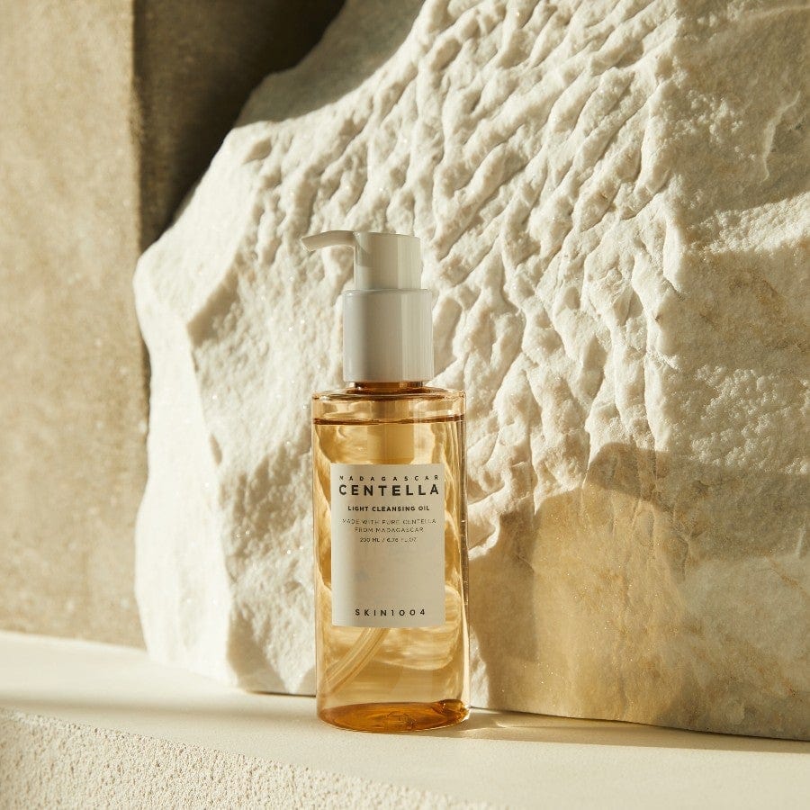 Skincare bottle with pump against a textured stone wall